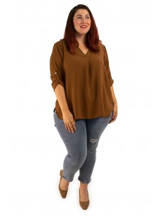 Mujer de talla grande luciendo la blusa de crepé elástico del outlet combinada con jeans azules. 2