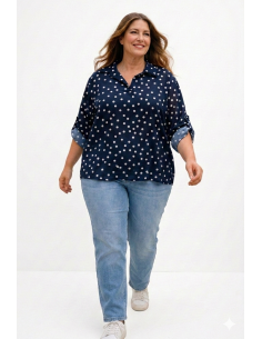 Mujer curvy sonriendo con blusa azul marino de lunares en tallas grandes y vaqueros baggy 2